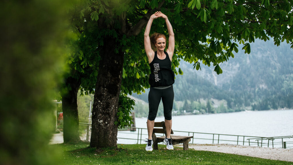 Eine Läuferin macht Strecksprünge am Achensee Ufer.
