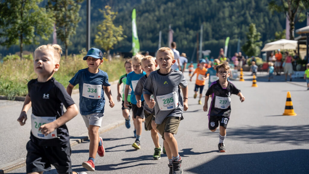 Beim Achensee Kinderlauf laufen Kinder bei sonnigem Wetter.